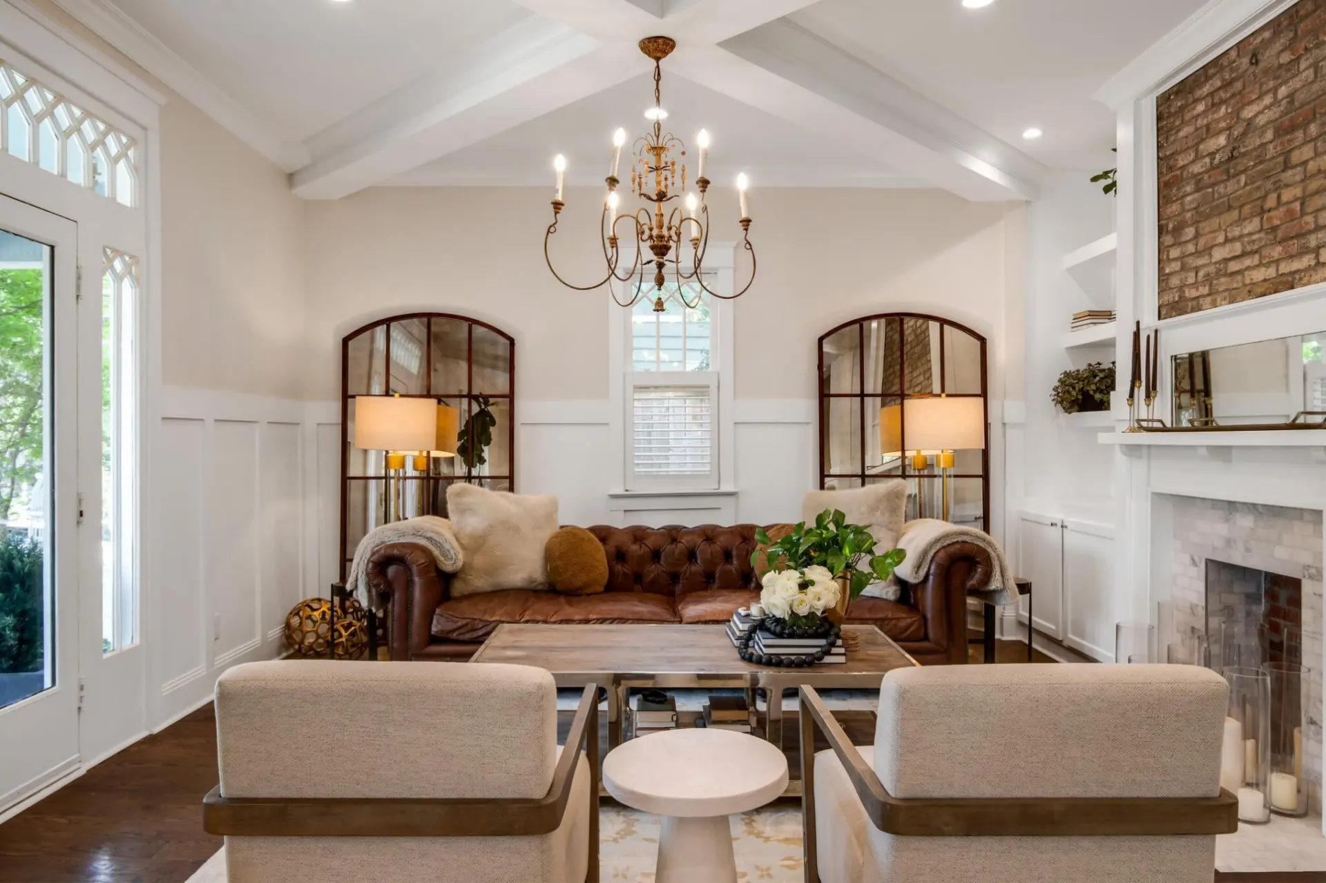 Staged living room with a leather chesterfield sofa, coffered ceiling and brick fireplace