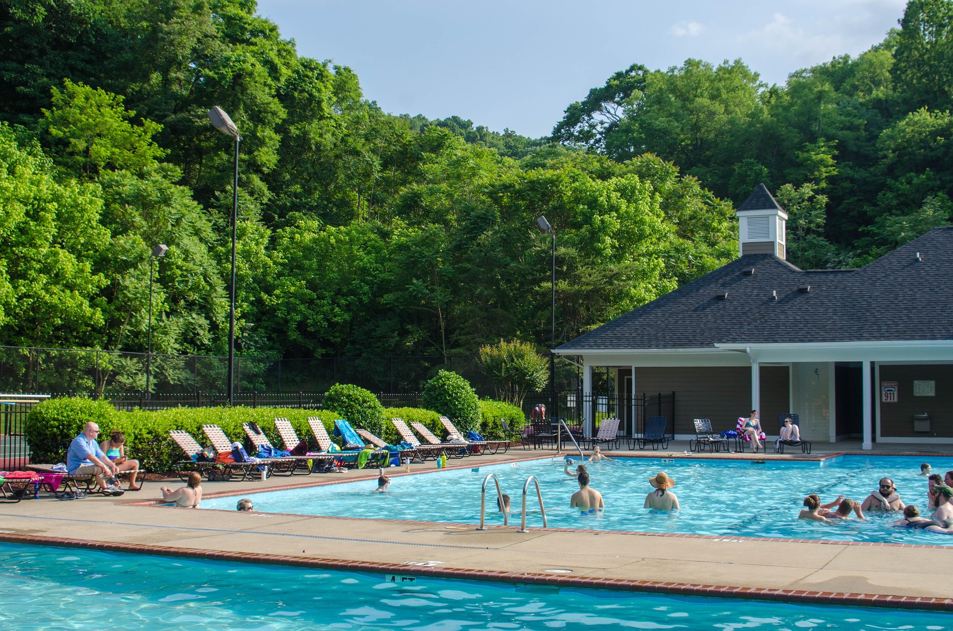 Neighborhood swim club pool and clubhouse surrounded by trees on a summer afternoon in Middle Tennessee